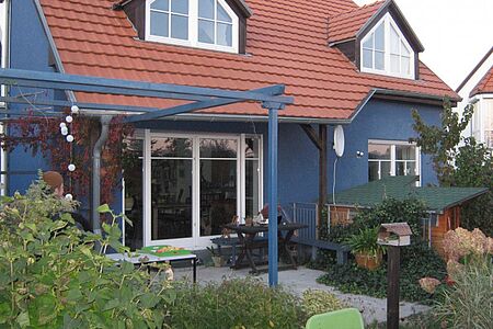 Großes Wohnhaus mit Terrasse und blauer Fassade