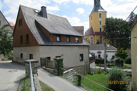 Ehemals weiße Fassade eines Wohnhauses weist Grünspan und starke Verschmutzungen auf