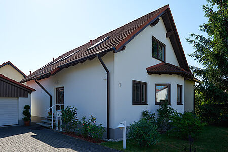 Weißes Einfamilienhaus mit frisch sanierter Fassade