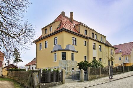 Villa mit drei Stockwerken und helloranger Fassade