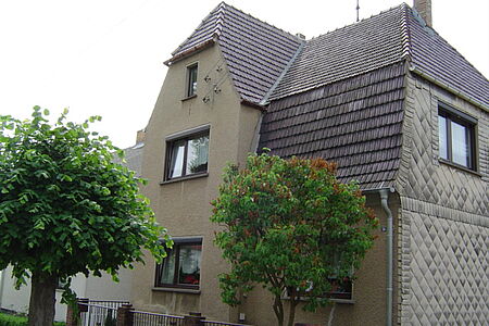 Großes Haus mit leicht verwitterter bräunlicher Fassade