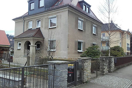 Steinfarbene Villa mit kleinen Fenster vor der Sanierung