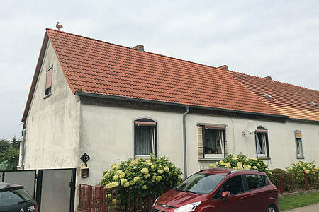Weißes Reihenhaus mit stark verschmutzter Fassade