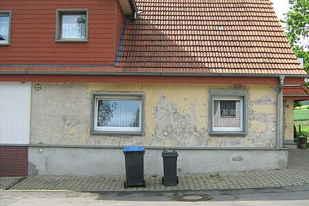 Zweistöckige Doppelhaushälfte mit bröckelnder Fassade