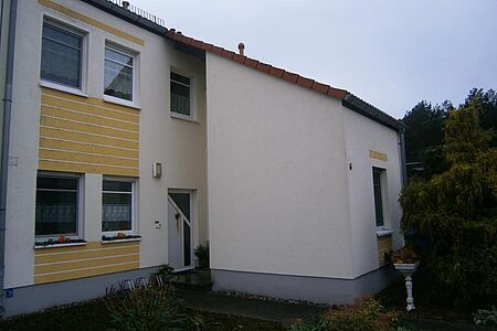 Mehrfamilienhaus mit Fassade in Weiß und Gelb