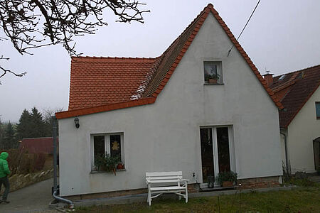 Weißes Wohnhaus mit stark verschmutzter Fassade