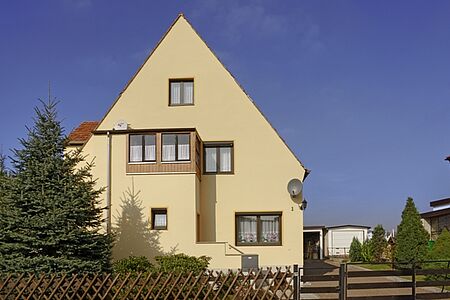 Haus mit hellgelber Fassade nach der Sanierung