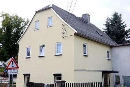 An der Straße liegendes Haus mit neuer weißer Fassade
