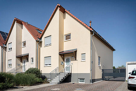 Reihenhaus mit Flachdach und frischem, pastellorangen Anstrich