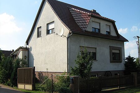 Wohnhaus mit alter Fassade in schmutzigem Weiß