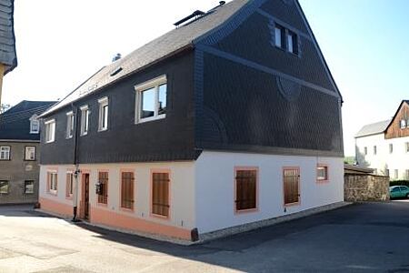 Mehrfamilienhaus mit sanierte Fassade im Erdgeschoss