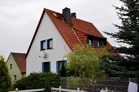 Weißes Wohnhaus mit blauen Fensterlöchern