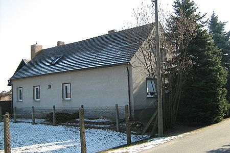 Langes Wohnhaus mit veralteter, grauer Fassade