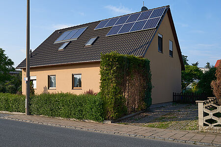 Oranges Wohnhaus mit Photovoltaik-Anlagen auf dem Dach