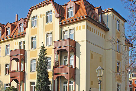 Saniertes Wohnhaus mit Holzbalkonen und mehreren Wohneinheiten