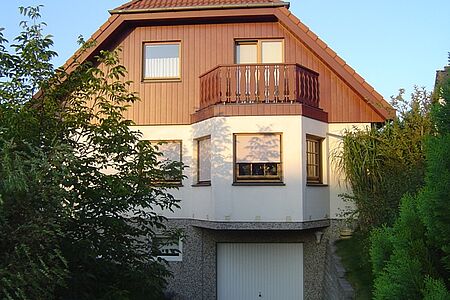 Haus mit Holzelementen und grau-weißer Fassade