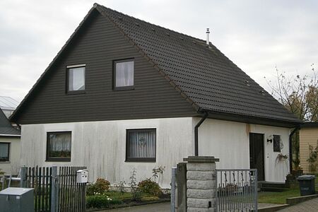 Haus mit weitflächig vergilbter Fassade im Erdgeschoss