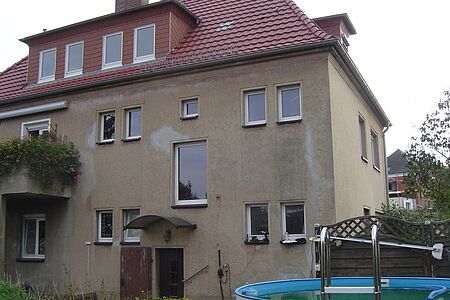 Dreistöckiges Mehrfamilienhaus mit bröckelnder Fassade in Braun