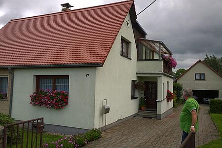 Doppelhaushälfte mit einer veralteten Fassade in mattem Hellgrün
