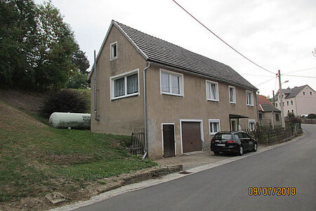 Reihenhaus mit braun verputzter, bröckelnder Fassade