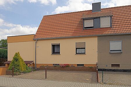 Doppelhaus mit Fassaden in hellem Orange und dunklem Beige