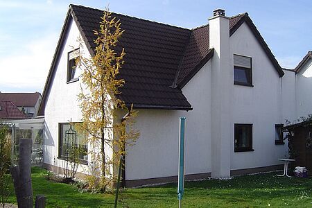 Großes Wohnhaus mit leicht beschmutzter weißer Fassade