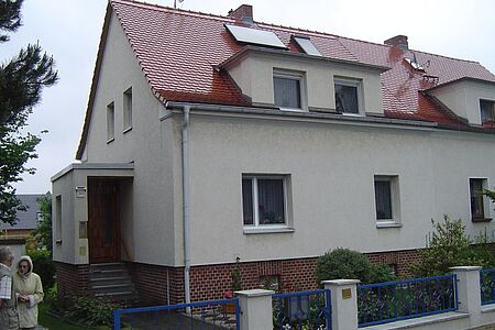 Beiges Einfamilienhaus mit sanierungsbedürftiger Fassade