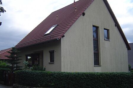 Einfamilienhaus mit grauer, stark verschmutzter Fassade