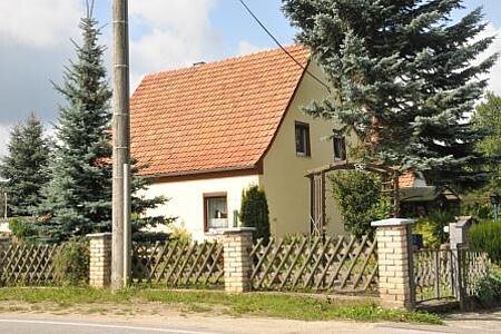 Einfamilienhaus mit spitzem Satteldach und pastellgelber Fassade