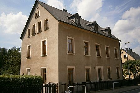 Mehrfamilienhaus mit großflächigen witterungsbedingten Schäden an Fassade
