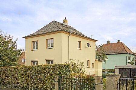Gelbes Haus mit drei Stockwerken und Walmdach