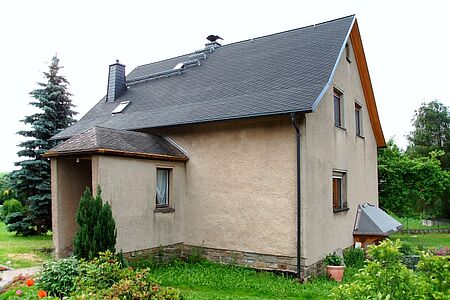 Fassade eines Einfamilienhauses mit deutlichen dunklen Stellen aufgrund von Regen