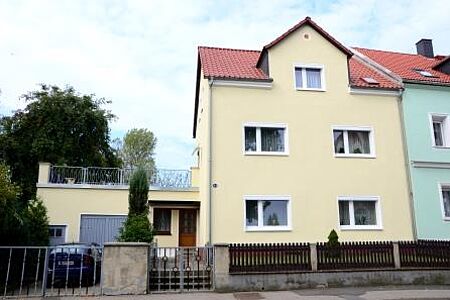 Pastellgelbes Reihenhaus mit Garage und Balkon