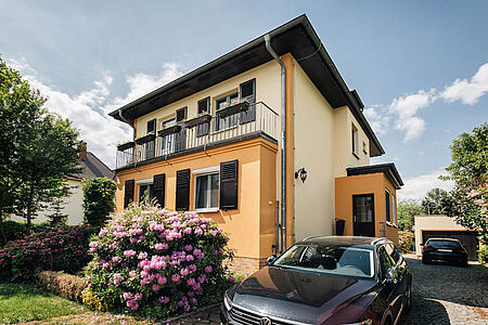 Großes Wohnhaus mit Balkon und ebenmäßiger Fassade in Beige und Orange