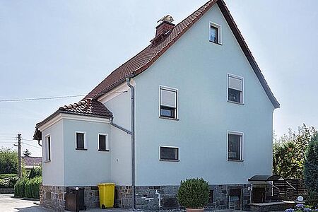 Hellblaues, dreistöckiges Wohnhaus nach der Sanierung