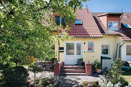 Pastellgelbes Reihenhaus mit frischer SPS Spezialputzfassade