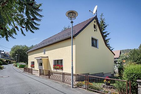 Weiß gestrichenes Wohnhaus mit saniertem Treppenaufgang