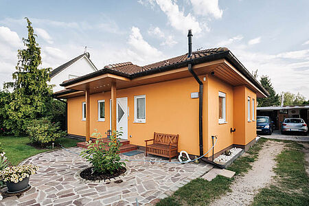Oranges Bungalow mit Walmdach und strahlender Fassade