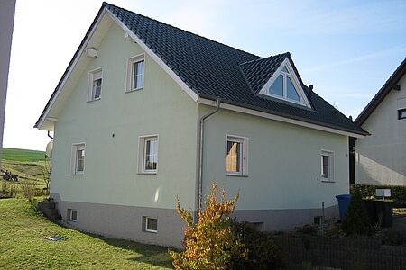 Mintgrünes Wohnhaus mit drei Stockwerken
