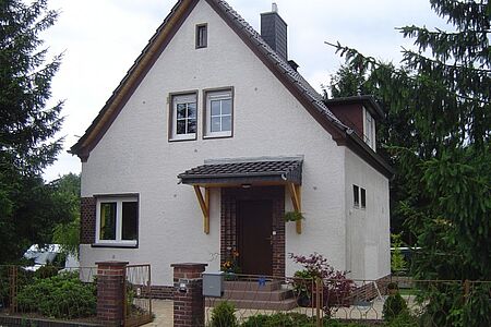 Einfamilienhaus mit veralteter und leicht verschmutzter Fassade in Weiß