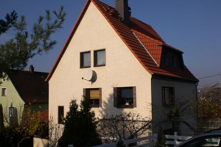 Helloranges Wohnhaus mit braunen Fensterlöchern