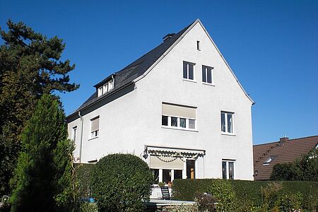 Großes weißes Wohnhaus vor der Fassadensanierung