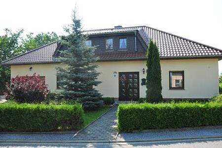 Hellgelbes Bungalow mit Walmdach und frischer Fassade