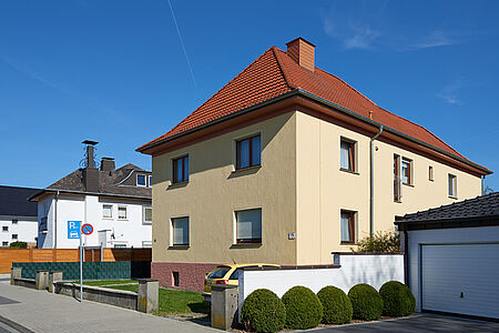 Mehrfamilienhaus mit Walmdach und SPS Spezialputzfassen in hellem Gelb