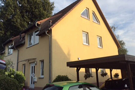Doppelhaushälfte mit einer Fassade in gelblichem Orange