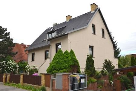 Zweifamilienhaus mit hellrosaner Fassade nach der Sanierung
