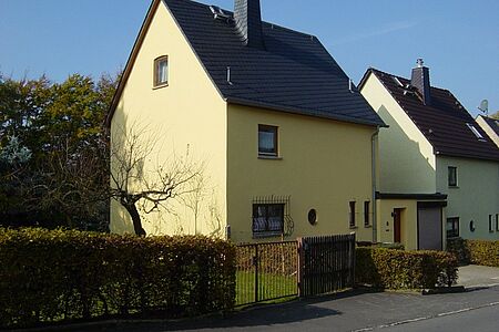 Dreistöckiges Haus mit gelber SPS Spezialputzfassade
