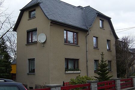 Haus mit drei Stockwerken und veralteter Fassade in Braun