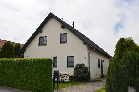 Großes Einfamilienhaus mit weißer Fassade nach der Sanierung