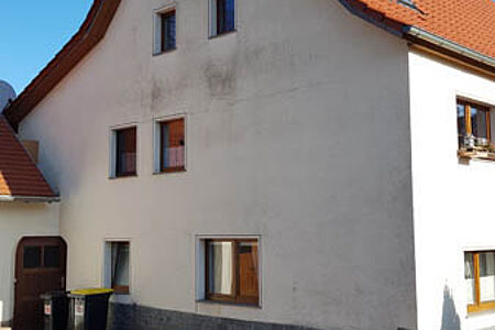 Wohnhaus mit verschmutzter, weißer Fassade